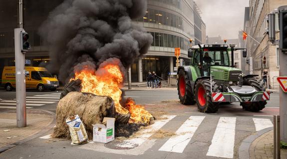 Αγρότες πετούν τα προϊόντα τους και ανάβουν φωτιές έξω από την Κομισιόν (ΒΙΝΤΕΟ)