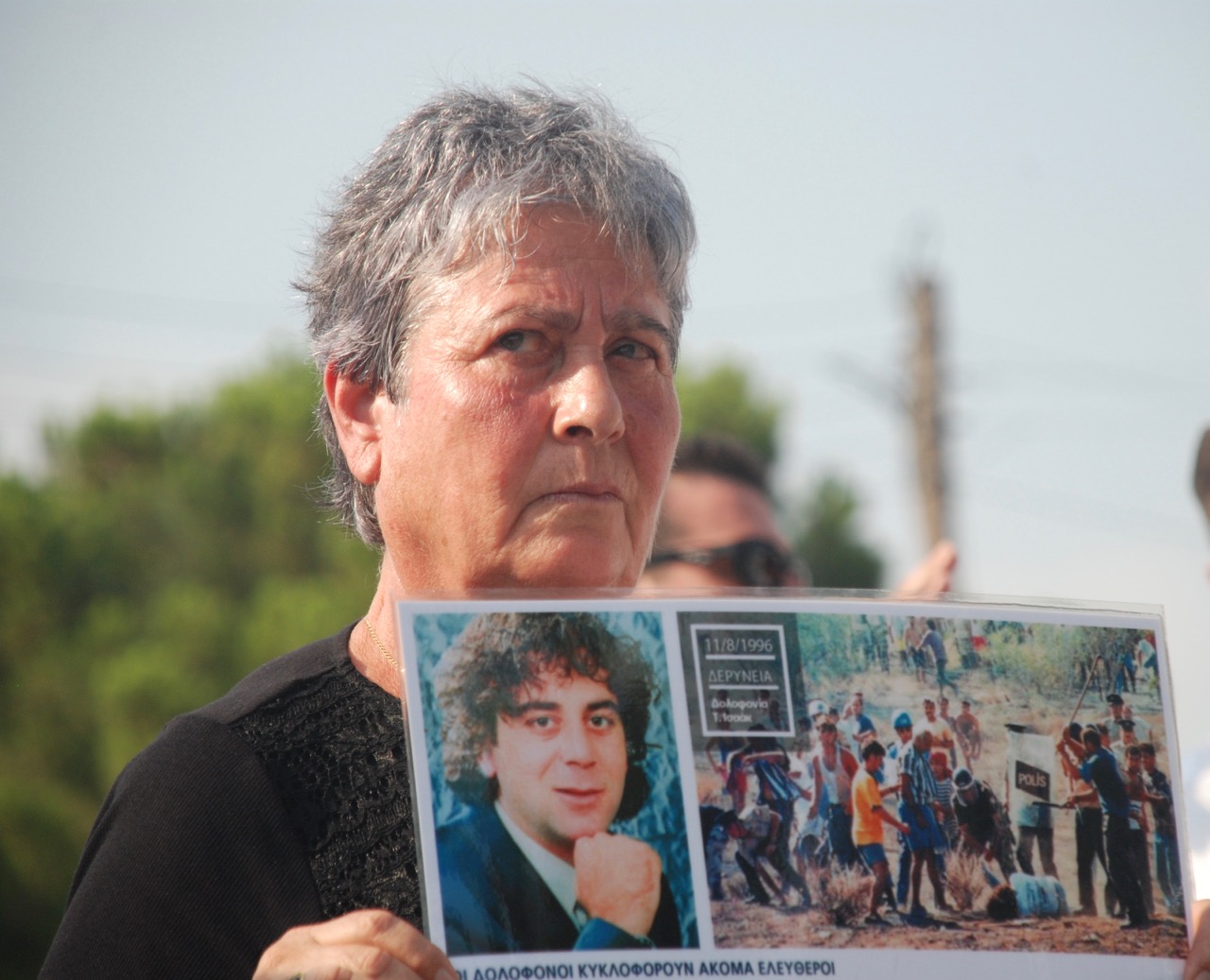 Με πλακάτ διαμαρτυρίας στο οδόφραγμα Δερύνειας η μάνα του Τάσου Ισαάκ (ΦΩΤΟ)